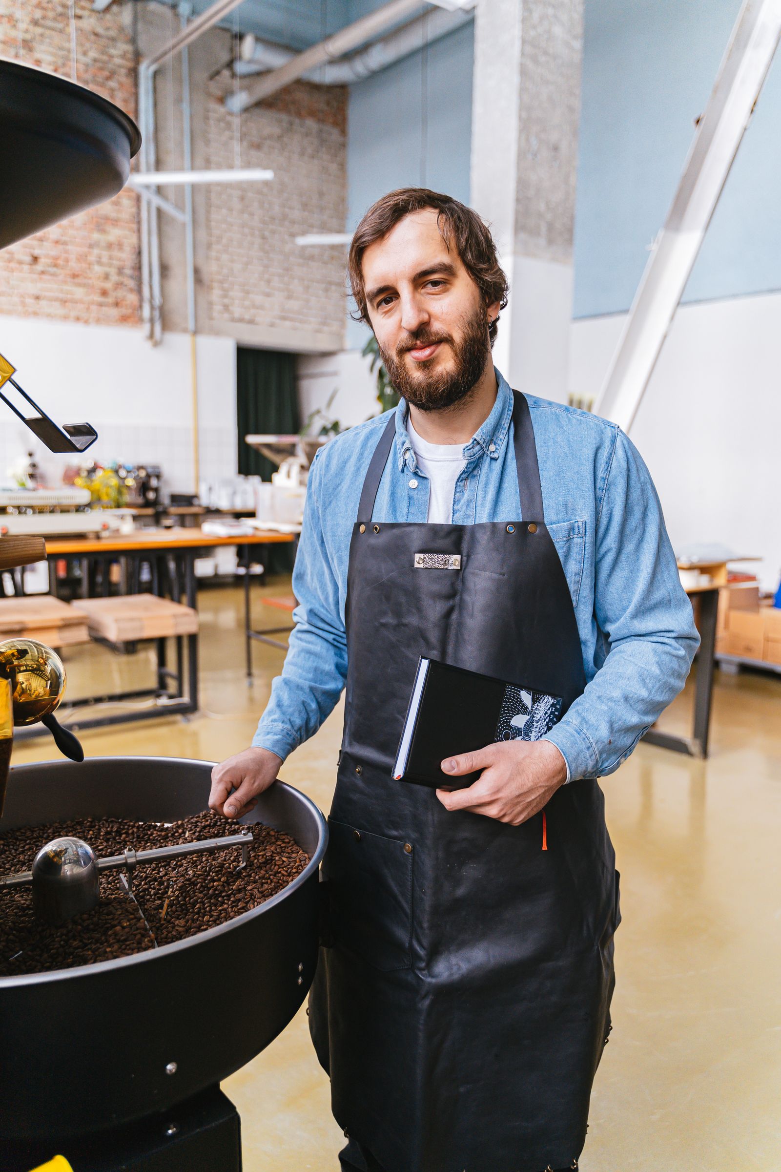 Coffee professional standing beside a roaster